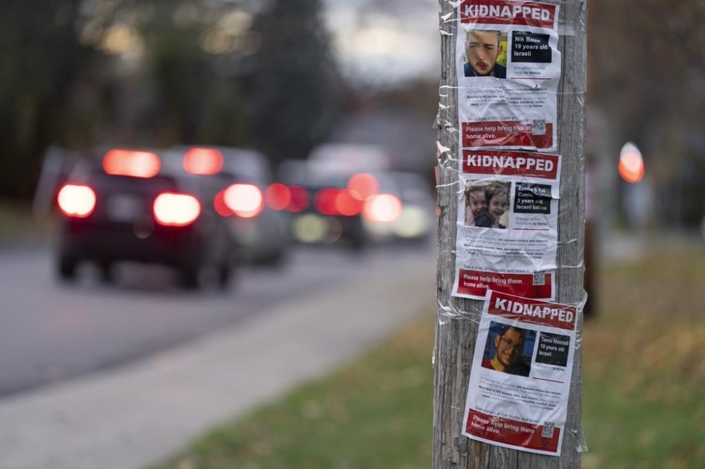 Posters are taped to a pole in Montreal showing kidnapped Israeli hostages, Tuesday, Nov., 14, 2023. THE CANADIAN PRESS/Christinne Muschi