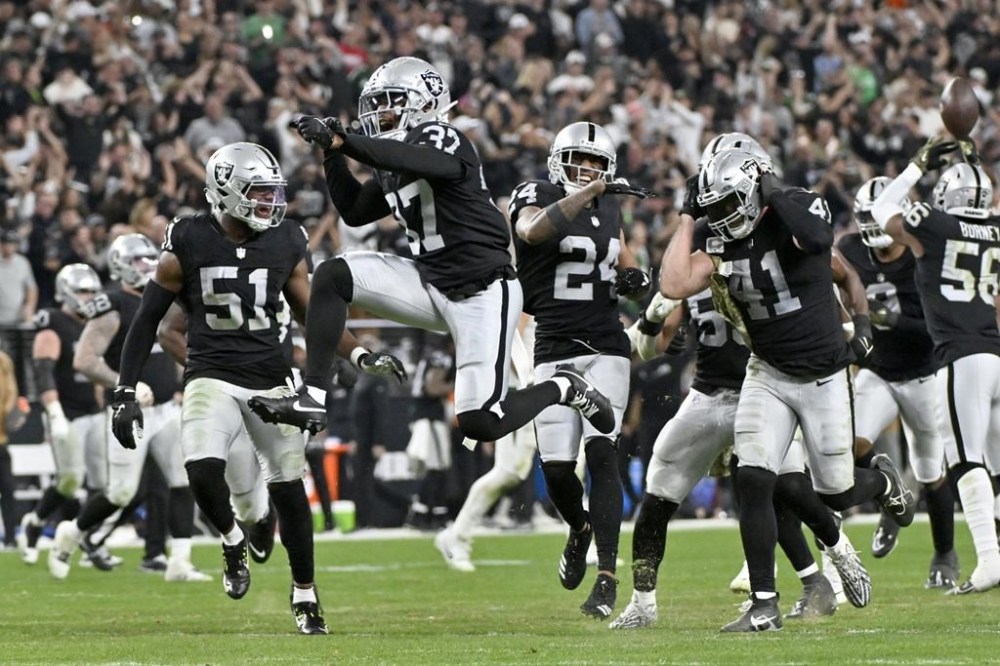 Las Vegas Raiders cornerback Tyler Hall (37) celebrates an interception by teammate Robert Spillane (41) as Raiders Malcolm Koonce (51) and Marcus Peters (24) watch during the second half of an NFL football game against the New York Jets Sunday, Nov. 12, 2023, in Las Vegas. (AP Photo/David Becker)