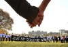 Demonstrators calling for a ceasefire in the Gaza Strip join hands on the field at Magazine Beach after blocking traffic on the nearby BU Bridge for several hours Thursday, Nov. 16, 2023 in Cambridge, Mass. (John Tlumacki/The Boston Globe via AP)