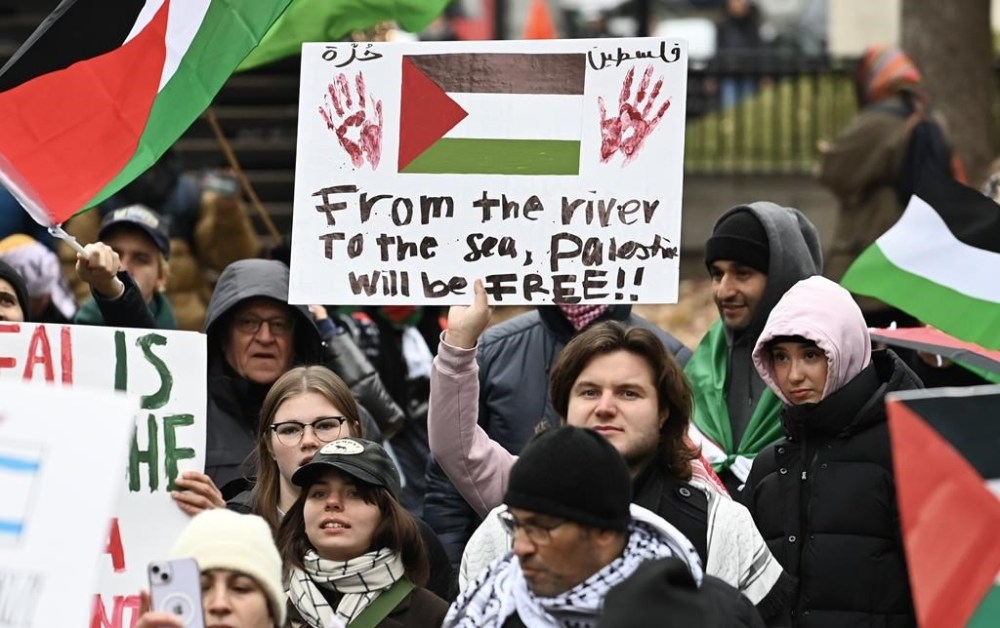 A person holds up a sign during a pro-Palestine rally in Montreal, Sunday, Nov. 12, 2023. A debate is raging over a phrase being chanted by pro-Palestinian activists at rallies across the country. THE CANADIAN PRESS/Graham Hughes