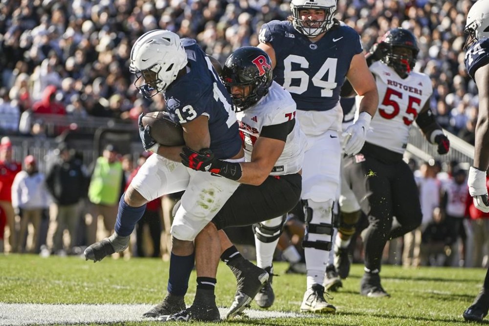 Penn State running back Kaytron Allen (13) scores a touchdown as Rutgers defensive lineman Aaron Lewis (71) defends during the first half of an NCAA college football game, Saturday, Nov. 18, 2023, in State College, Pa. (AP Photo/Barry Reeger)