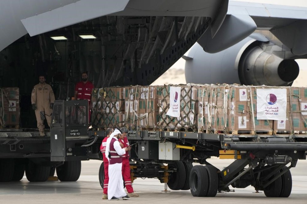 Qatari Red Crecent officials deliver humanitarian aids at Al Arish airport, Egypt, on its way to Gaza, Sunday, Nov.19, 2023. (AP Photo/Amr Nabil)