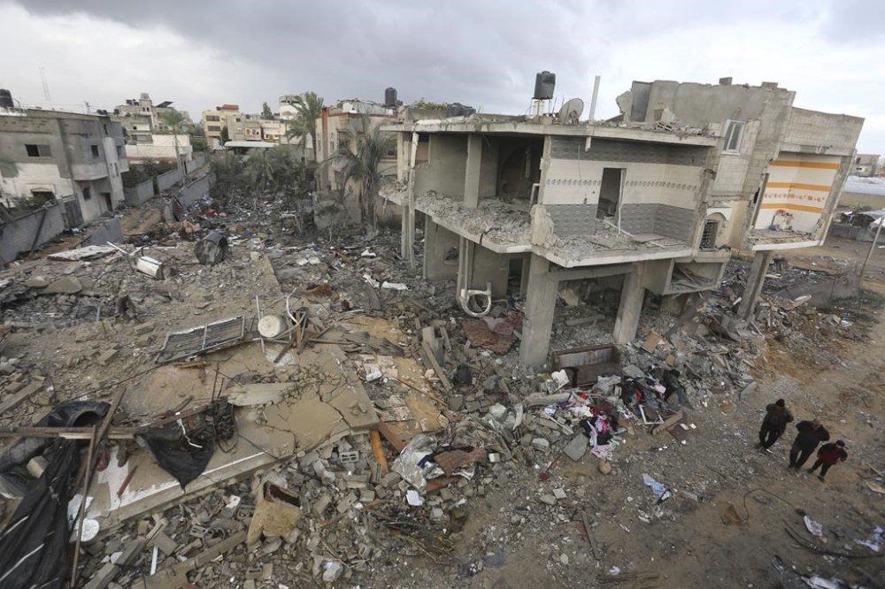 Palestinians look at houses destroyed in the Israeli bombardment of the Gaza Strip in Rafah on Monday, Nov. 20, 2023. AP Photo/Hatem Ali)