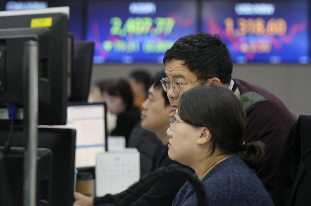 FILE - Currency traders watch monitors at the foreign exchange dealing room of the KEB Hana Bank headquarters in Seoul, South Korea, on Nov. 10, 2023. Shares were mixed in Asia on Friday, Nov. 23, with Hong Kong retreating on selling of property shares following recent gains. (AP Photo/Ahn Young-joon, File)