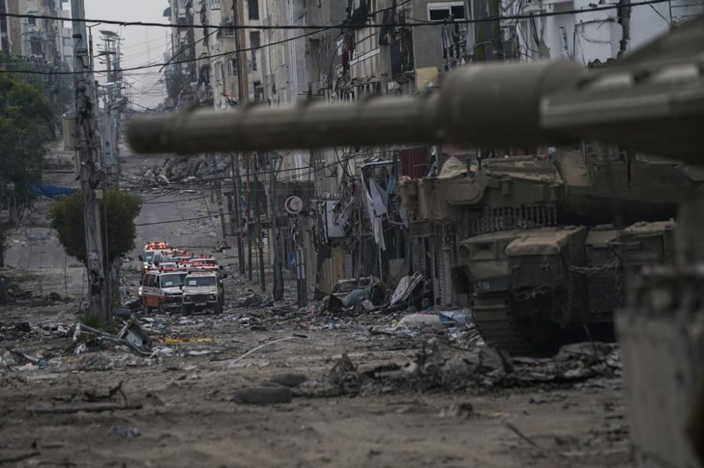 Ambulances are seen on a road near an Israeli forces tank during an Israeli army ground operation in the Gaza Strip, Wednesday, Nov. 22, 2023. (AP Photo/Victor R. Caivano)