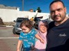 This photo provided by Hosein Owda dated Sunday, Oct. 15, 2023 shows him with his wife, Wafa, and 1-year-old son Zein at the shelter in Khan Younis. The Owda family had arrived two days earlier to the shelter after they lost their apartment. They are now among 22,000 people sheltering at a UN center in Khan Younis, miles away from their home in Gaza city. (Hosein Owda via AP)