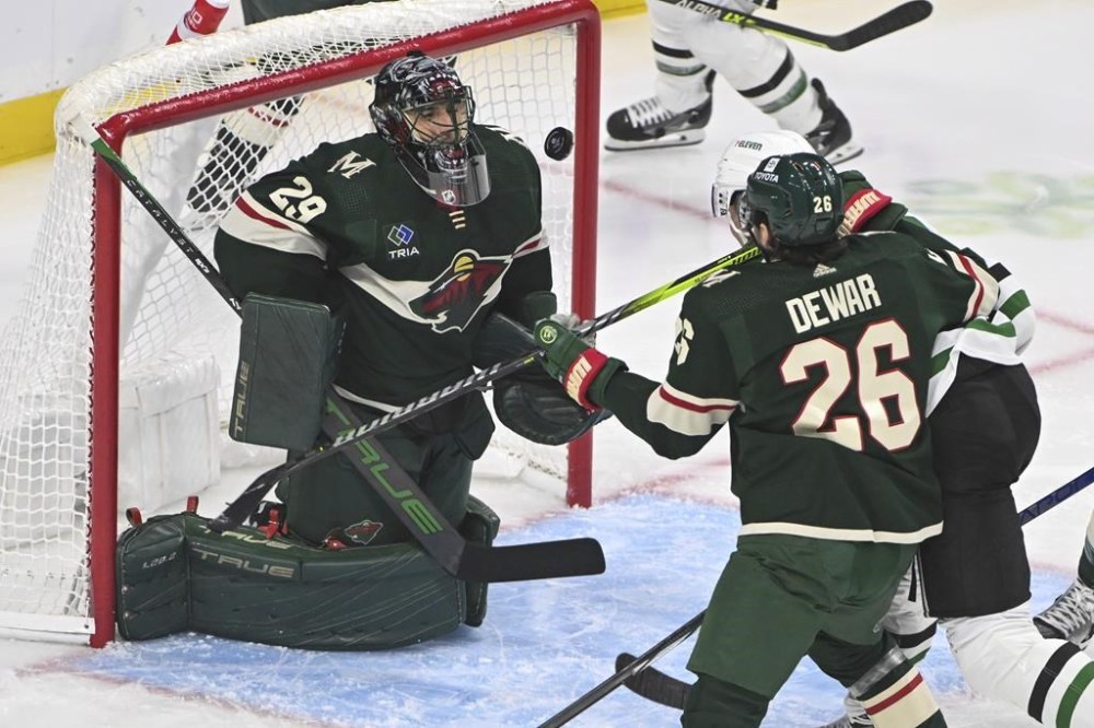 Minnesota Wild goalie Marc-Andre Fleury (29) blocks a shot by Dallas Stars center Radek Faksa, back right, as Wild center Connor Dewar tries to clear Faska from the goal during the first period of an NHL hockey game Sunday, Nov. 12, 2023, in St. Paul, Minn. (AP Photo/Craig Lassig)