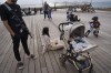 An off-duty Israeli soldier and his family enjoy the day at the Tel Aviv port on the second day of a cease-fire between Israel and Hamas, Saturday, Nov. 25, 2023. Israel prepared Saturday to release several dozen Palestinian prisoners in exchange for around 14 hostages held by Hamas in Gaza. (AP Photo/Oded Balilty)