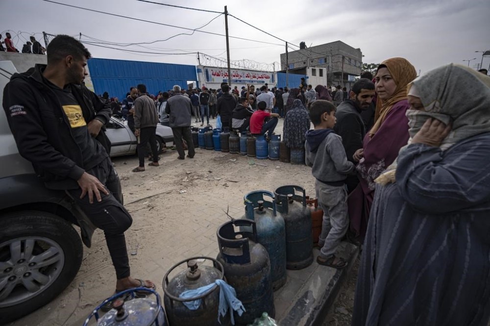 Palestinians line up for cooking gas during the second day of the temporary ceasefire between Hamas and Israel in Khan Younis, Gaza Strip, Saturday, Nov. 25, 2023. (AP Photo/Fatima Shbair)