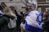 A woman wrapped in the Israeli flag takes part in an anti-Semitism demonstration in London, Sunday, Nov. 26, 2023. (AP Photo/Alberto Pezzali)