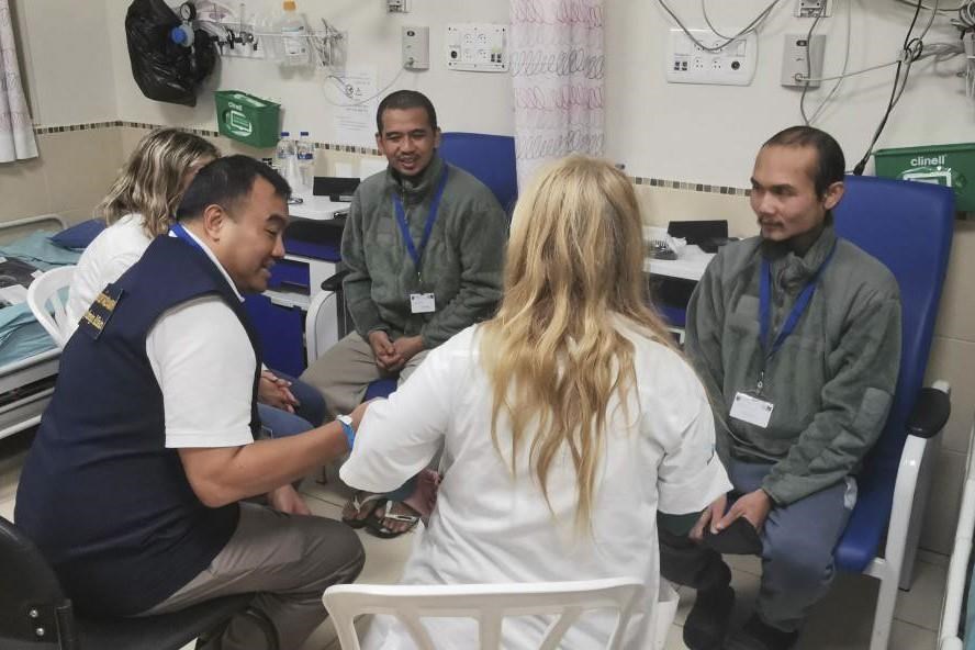 In this photo provided by Thailand's Foreign Ministry, two newly freed Thai hostages talk to a Thai officer, left center, at the Shamir Medical Center in Israel on Sunday, Nov. 26, 2023. Hamas freed several Thai nationals seized in the group's surprise attack on southern Israel last month, releasing them alongside Israeli hostages under a cease-fire deal. (Thailand's Foreign Ministry via AP )