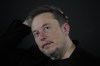 FILE - Elon Musk reacts during an in-conversation event with Britain's Prime Minister Rishi Sunak in London, Thursday, Nov. 2, 2023. IBM has stopped advertising on social media platform X after a report said its ads were appearing alongside material praising Adolf Hitler and Nazis — a fresh setback as the site formerly known as Twitter tries to win back big brands and their ad dollars.(AP Photo/Kirsty Wigglesworth, Pool, File)