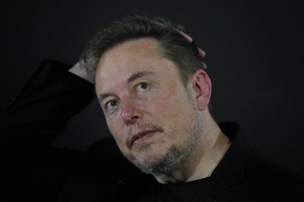 FILE - Elon Musk reacts during an in-conversation event with Britain's Prime Minister Rishi Sunak in London, Thursday, Nov. 2, 2023. IBM has stopped advertising on social media platform X after a report said its ads were appearing alongside material praising Adolf Hitler and Nazis — a fresh setback as the site formerly known as Twitter tries to win back big brands and their ad dollars.(AP Photo/Kirsty Wigglesworth, Pool, File)