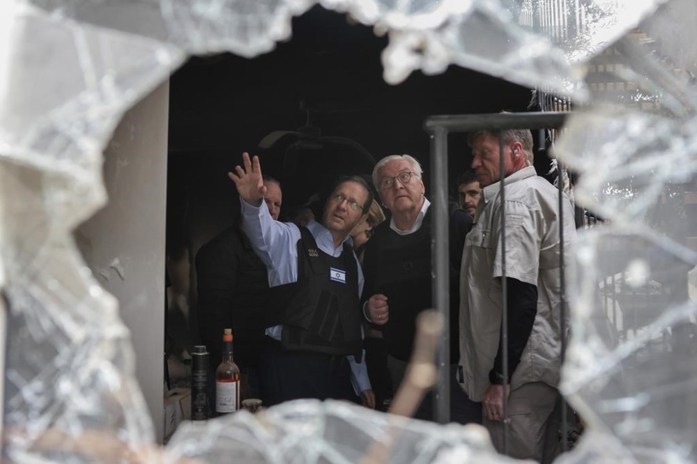 Israel's President Isaac Herzog, center left, and German President Frank-Walter Steinmeier, center right, visit Kibbutz Beeri in southern Israel, Monday, Nov. 27, 2023. (Ronen Zvulun/Pool Photo via AP)