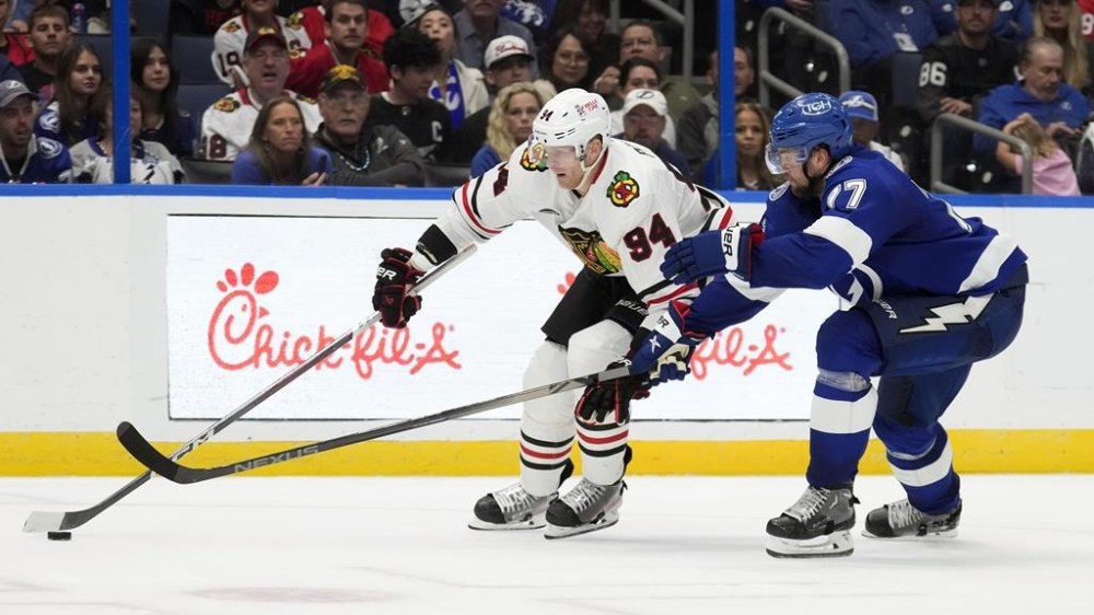 Chicago Blackhawks right wing Corey Perry (94) gets around Tampa Bay Lightning defenseman Victor Hedman (77) during the third period of an NHL hockey game Thursday, Nov. 9, 2023, in Tampa, Fla. (AP Photo/Chris O'Meara)