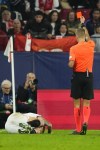 Referee Davide Massa shows a red card to Sevilla's Lucas Ocampos during the Champions League Group B soccer match between Sevilla and PSV at the Ramon Sanchez-Pizjuan stadium in Seville, Spain, Wednesday, Nov.29, 2023. (AP Photo/Jose Breton)