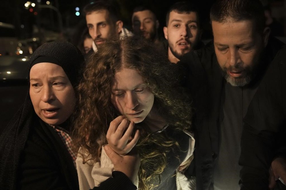Palestinian activist Ahed Tamimi, center is supported by her mother after she was released from prison by Israel, in the West Bank town of Ramallah, early Thursday, Nov. 30, 2023. International mediators on Wednesday worked to extend the truce in Gaza, encouraging Hamas militants to keep freeing hostages in exchange for the release of Palestinian prisoners and further relief from Israel's air and ground offensive. (AP Photo/Nasser Nasser)