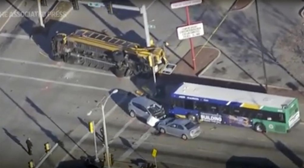 This image made from video provided by WISN-TV shows where a vehicle wanted in connection with a homicide in Chicago crashed into a school bus during a police chase in Milwaukee on Wednesday, Nov. 29, 2023, sending multiple people to area hospitals. (WISN-TV via AP)