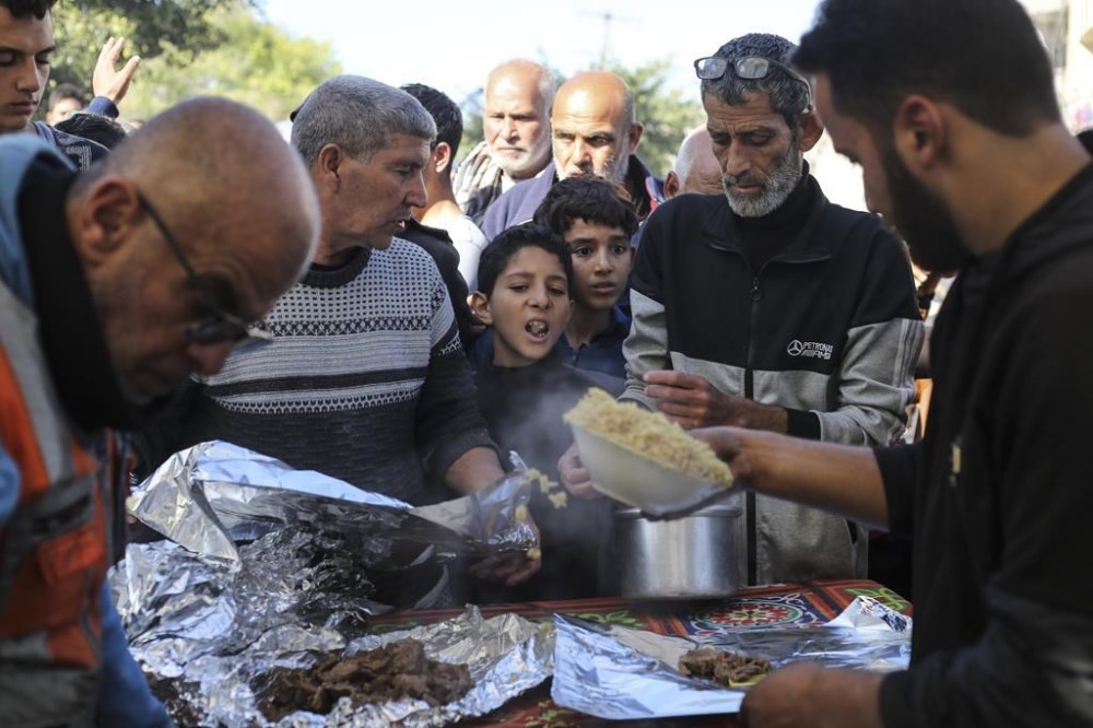 Palestinians line up for food in Rafah, Gaza Strip, Thursday, Nov. 30, 2023, during a temporary ceasefire between Israel and Hamas. (AP Photo/Hatem Ali)