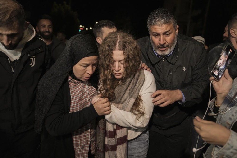 Palestinian activist Ahed Tamimi, center, is supported by her mother after she was released from prison by Israel, in the West Bank town of Ramallah, early Thursday, Nov. 30, 2023. International mediators on Wednesday worked to extend the truce in Gaza, encouraging Hamas militants to keep freeing hostages in exchange for the release of Palestinian prisoners and further relief from Israel's air and ground offensive. (AP Photo/Nasser Nasser)
