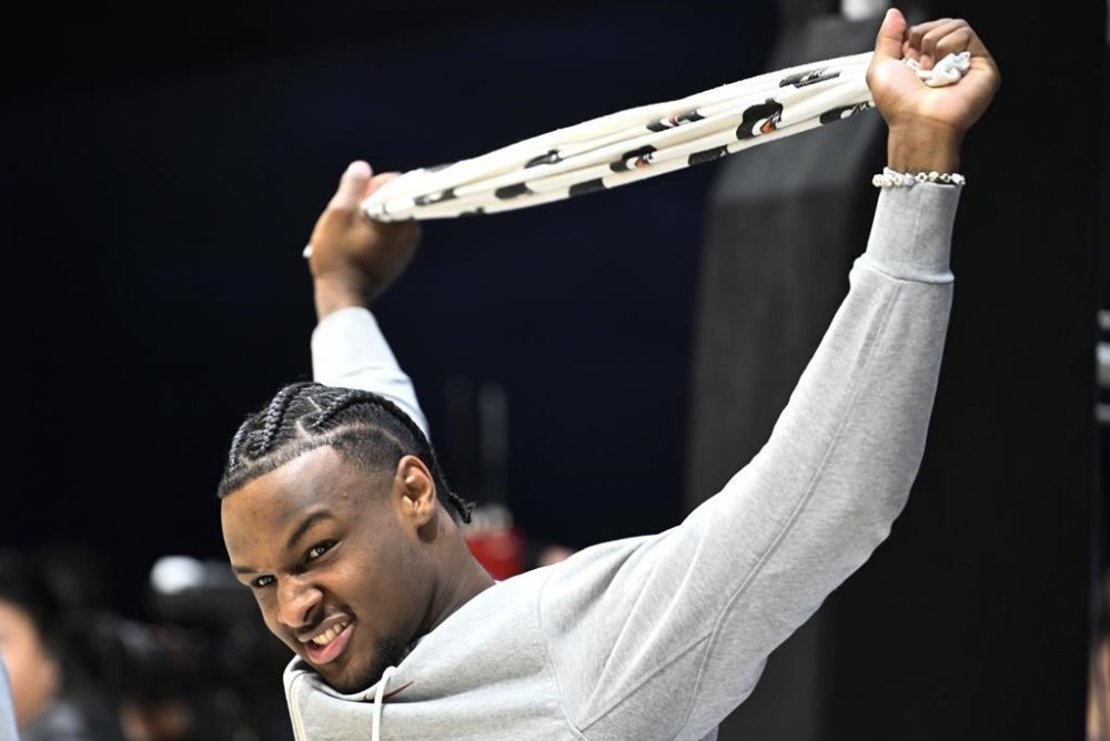 Southern California guard Bronny James stretches as teammates warmed up for an NCAA college basketball game against Seton Hall on Thursday, Nov. 23, 2023, in San Diego. James suffered a cardiac arrest in July. (AP Photo/Denis Poroy)