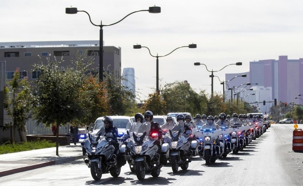 Nevada State Police and Las Vegas Metro Police officers on motorcycles lead a procession carrying the body of a state trooper to the Clark County Coroner's Office in Las Vegas Thursday, Nov. 30, 2023. Two troopers who were assisting a motorist early Thursday morning were hit by a vehicle and killed, according to Nevada State Police. (Steve Marcus/Las Vegas Sun via AP)