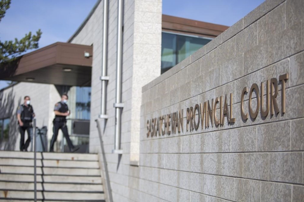 Deputy sheriffs walk into the Saskatchewan Provincial courthouse in Prince Albert, Sask., on May 13, 2021. The first-degree murder trial of a former Saskatchewan Mountie is set to begin. Bernie Herman was charged with first-degree murder in the death of 26-year-old Braden Herman in 2021. THE CANADIAN PRESS/Kayle Neis