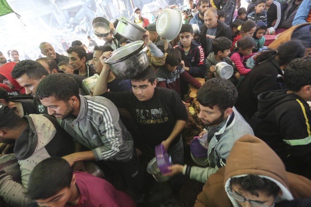 Palestinians line up for food in Rafah, Gaza Strip, Thursday, Nov. 30, 2023, during a temporary ceasefire between Israel and Hamas. (AP Photo/Hatem Ali)