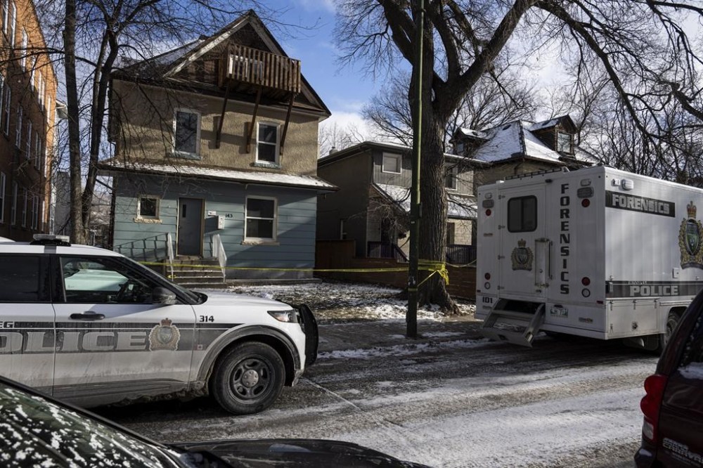 Police vehicles are shown outside the scene of a shooting at a home in Winnipeg on Monday, Nov. 27, 2023. Police in say they have laid charges in the shooting that left four people dead and one injured. THE CANADIAN PRESS/Aaron Vincent Elkaim