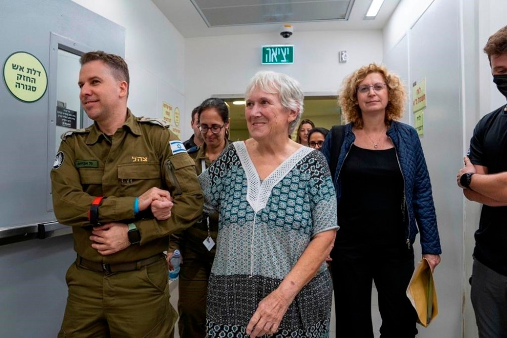 FILE - In this photo provided by the Israeli army, released Israeli hostage Margalit Mozes walks with an Israeli soldier upon her arrival in Israel on Nov. 24, 2023, after being held hostage by Hamas in the Gaza Strip. An Associated Press review of Hamas instruction manuals shows the group planned ahead of time to target civilians. (Israel Defense Forces via AP, File)