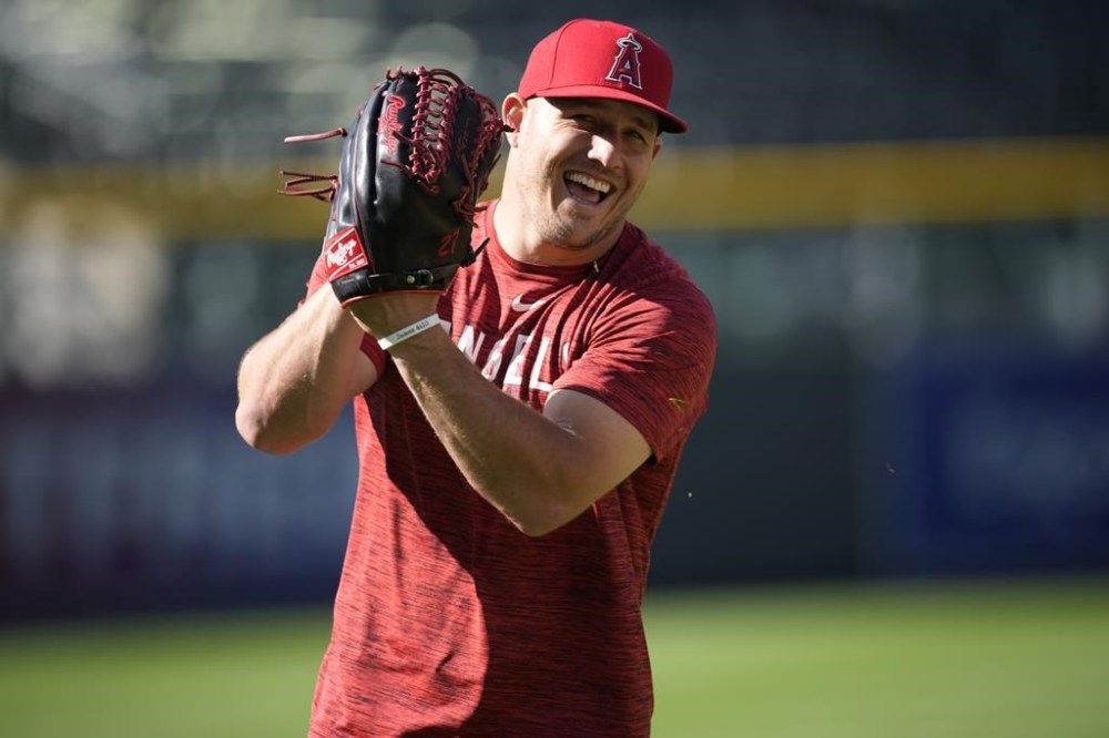 FILE - Los Angeles Angels center fielder Mike Trout warms up before a baseball game against the Colorado Rockies, Saturday, June 24, 2023, in Denver. The Angels will not trade three-time AL MVP Mike Trout. General manager Perry Minasian confirmed it at MLB’s winter meetings. (AP Photo/David Zalubowski, File)