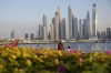 People walk with the skyline in the background as Dubai, United Arab Emirates, hosts the COP28 U.N. Climate Summit, Tuesday, Dec. 5, 2023. (AP Photo/Kamran Jebreili)