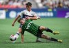 Austin FC's Jon Gallagher, front, falls while vying for the ball against Vancouver Whitecaps' Sebastian Berhalter during the second half of an MLS soccer match in Vancouver on Wednesday, July 12, 2023. THE CANADIAN PRESS/Darryl Dyck
