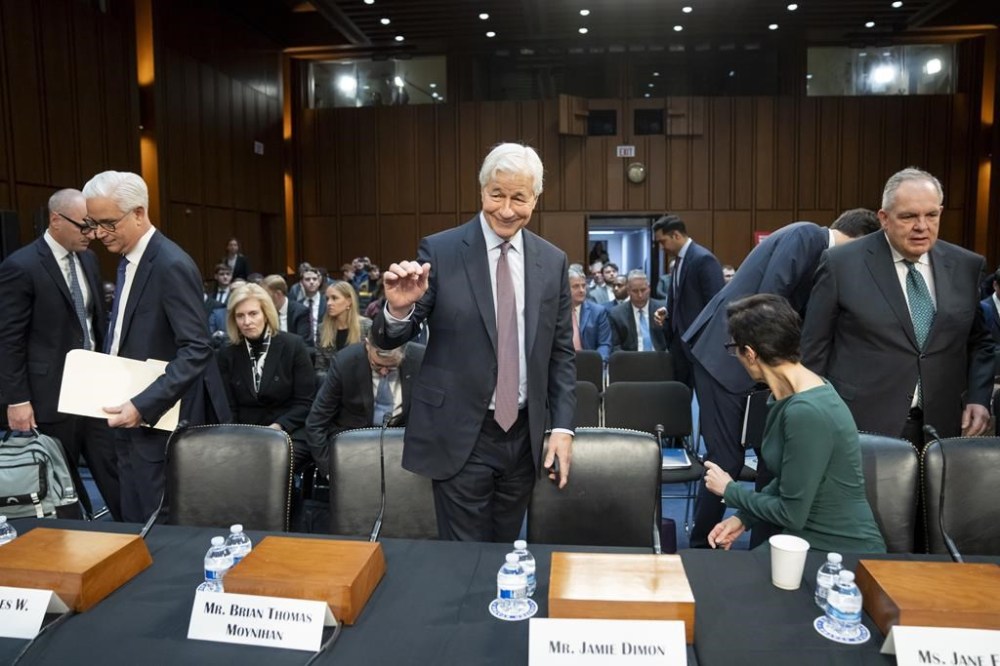 Charles W. Scharf, second from left, CEO and President, Wells Fargo & Company; Jamie Dimon, Chairman and CEO, JPMorgan Chase & Co.; Jane Fraser, seated, CEO, Citigroup; and Ronald O'Hanley, CEO, State Street; take their seats before a Senate Banking, Housing, and Urban Affairs Committee oversight hearing to examine Wall Street firms on Capitol Hill, Wednesday, Dec. 6, 2023, in Washington. (AP Photo/Alex Brandon)