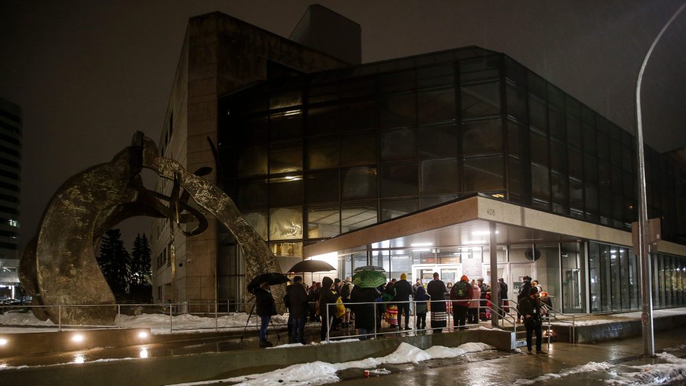 Around three dozen family members and supporters braved the November rain and gathered outside the Manitoba Law Courts building Sunday night to participate in a candlelight vigil. (John Woods / Winnipeg Free Press)