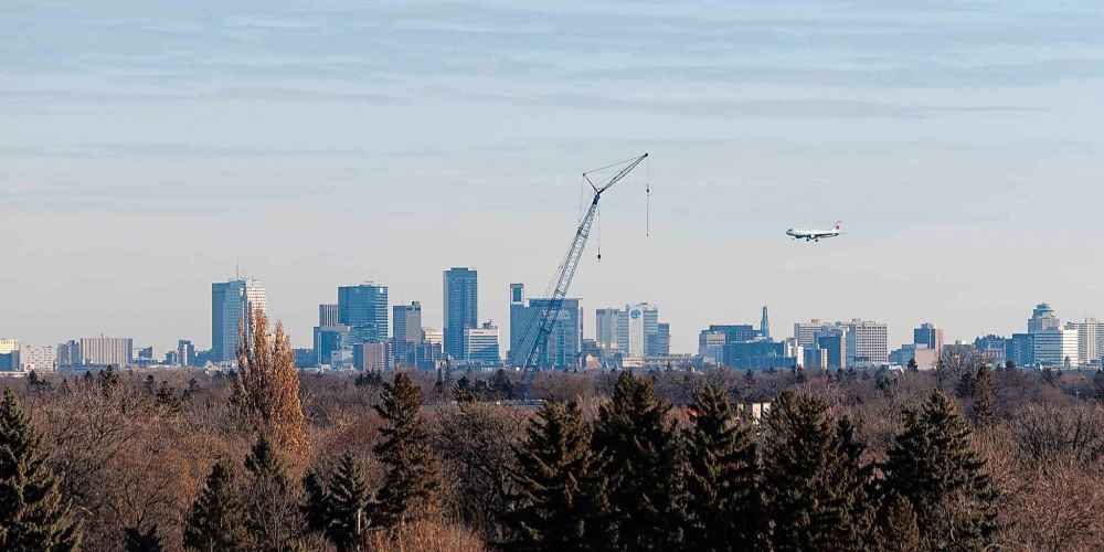 MIKE DEAL / WINNIPEG FREE PRESS
A plane approaches Winnipeg's airport over the city's skyline.