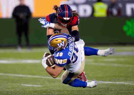 Winnipeg Blue Bombers running back Brady Oliveira (20) is tackled by Montreal Alouettes defensive back Marc-Antoine Dequoy (24) during the second half of football action at the 110th CFL Grey Cup in Hamilton. (Frank Gunn / The Canadian Press)