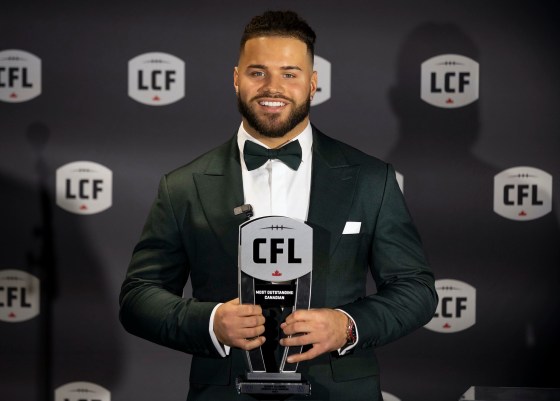 Winnipeg Blue Bombers' Brady Oliveira with his award for Most Outstanding Canadian at the 2023 Canadian Football League Awards in Niagara Falls, Ont., Thursday. (ara Walton / The Canadian Press)
