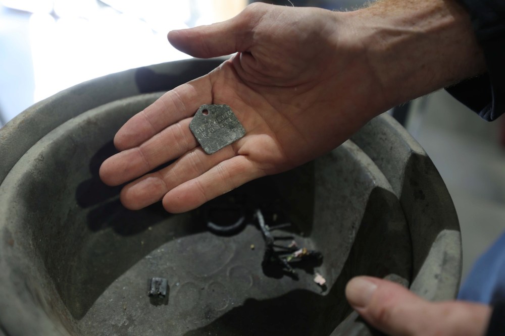RUTH BONNEVILLE / WINNIPEG FREE PRESS
                                A dog tag is removed from an animal before final processing.