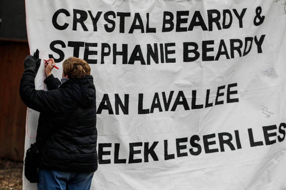 A large white banner strung up between two trees replaced last week’s police tape, listing the names of the four people killed and read: “You are missed. You are loved.” (John Woods / Winnipeg Free Press)