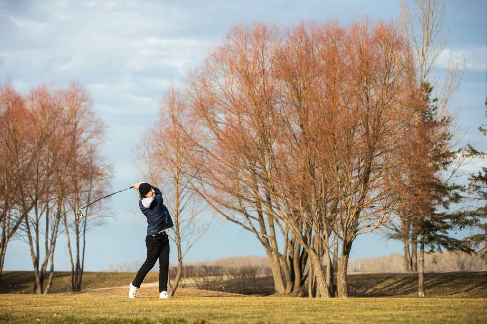 MIKAELA MACKENZIE / WINNIPEG FREE PRESS
Connor Kehler tees off at Southside Golf Course where the only change from summer play, besides the regular greens being closed with temporary holes set up in front of them, was the frozen ground made it difficult to put a tee in.