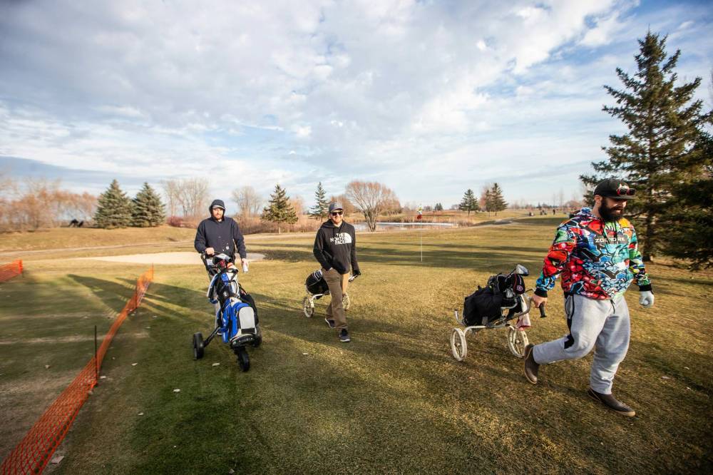 MIKAELA MACKENZIE / WINNIPEG FREE PRESS
Nick Mulvey (left), Brian Stover, and Philip Da Silva get in a round of golf at Southside Golf Course Thursday, which is open in December for the first time ever due to the unusually mild weather.