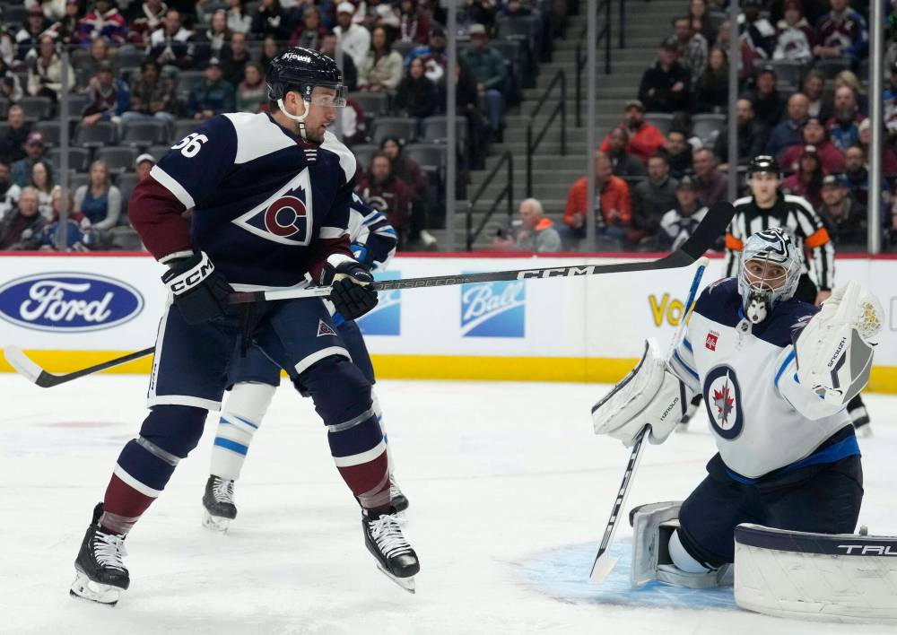 (AP Photo/David Zalubowski)
Colorado Avalanche defenceman Kurtis MacDermid, left, has his shot stopped by Winnipeg Jets goaltender Connor Hellebuyck during the first period Thursday, in Denver.