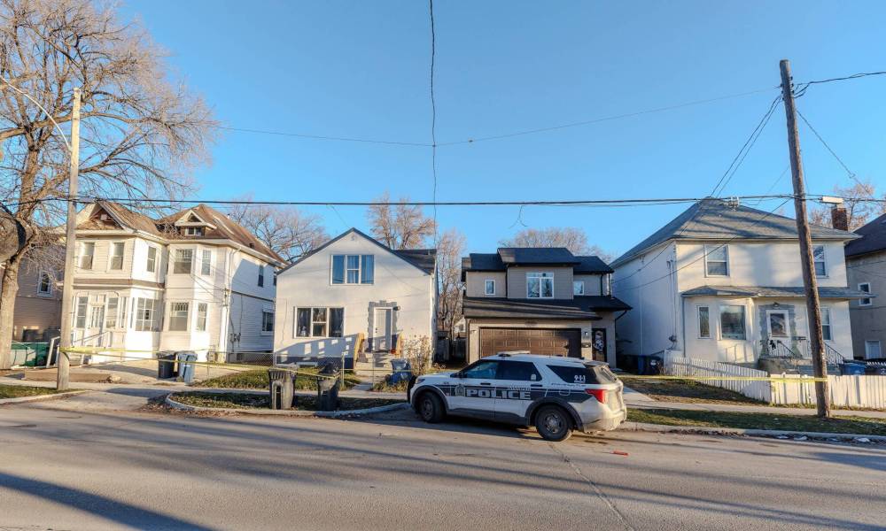 MIKE DEAL / FREE PRESS FILES
Forensics officers work in and around the front yard of 451 Burrows Ave. and adjacent 447 Burrows Ave.