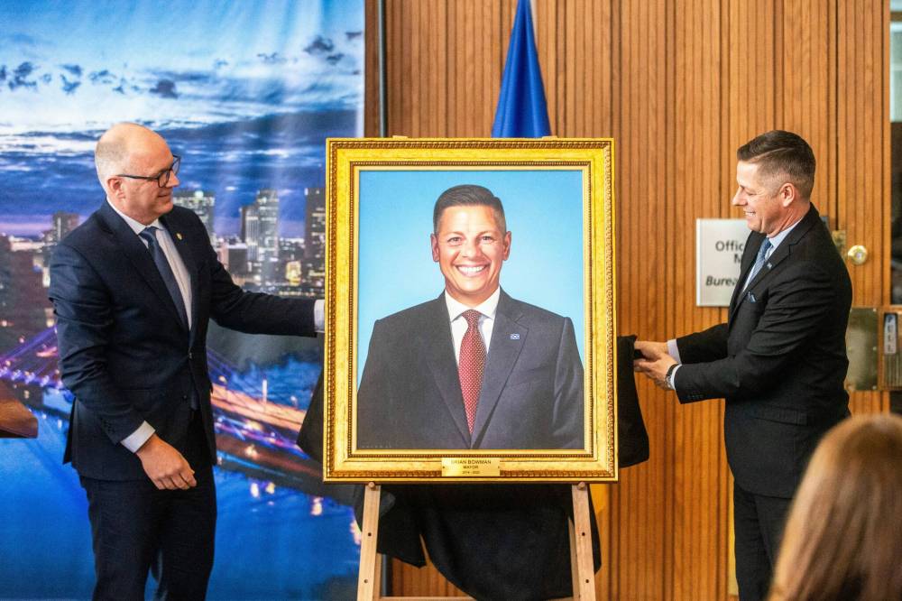 MIKAELA MACKENZIE / WINNIPEG FREE PRESS
Mayor Scott Gillingham (left) and former mayor Brian Bowman unveil Bowman’s mayoral portrait at City Hall on Monday.