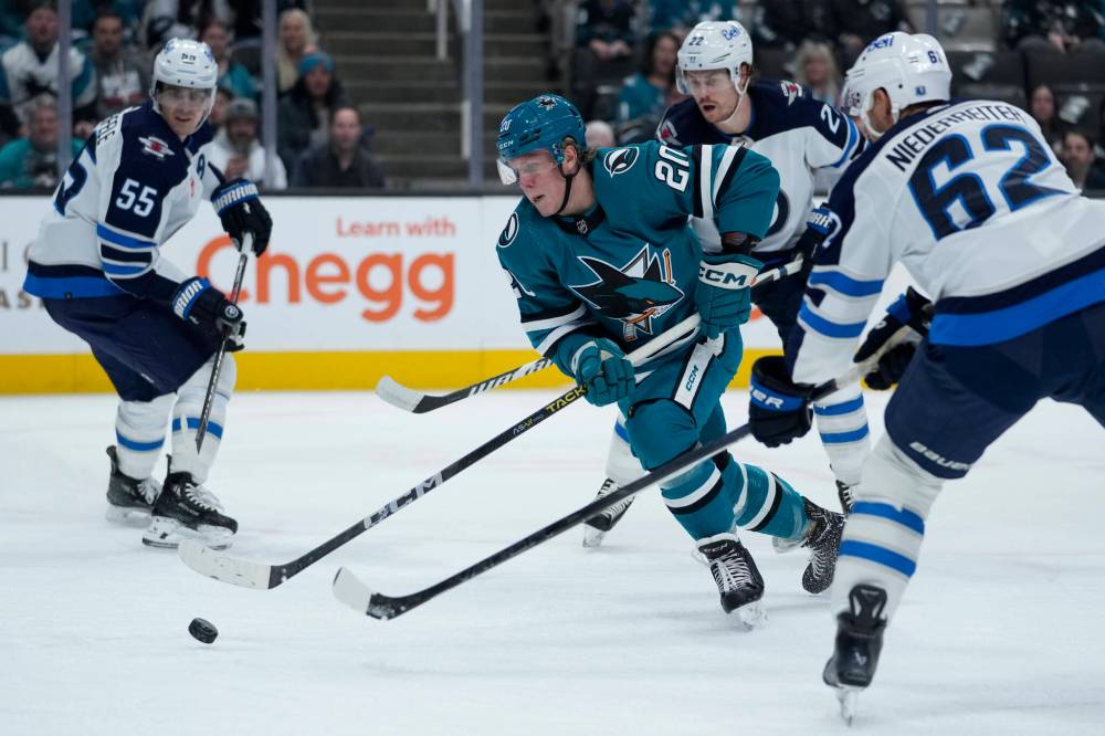 Godofredo A. Vásquez / The Associated Press
San Jose Sharks left wing Fabian Zetterlund moves the puck between Winnipeg Jets players during the first period.