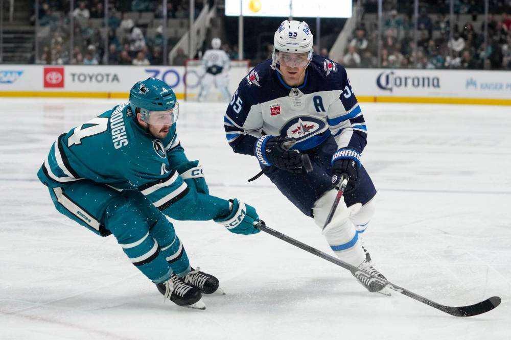 Godofredo A. Vásquez / The Associated Press
San Jose Sharks defenceman Kyle Burroughs, left, and Winnipeg Jets centre Mark Scheifele chase the puck during the second period.