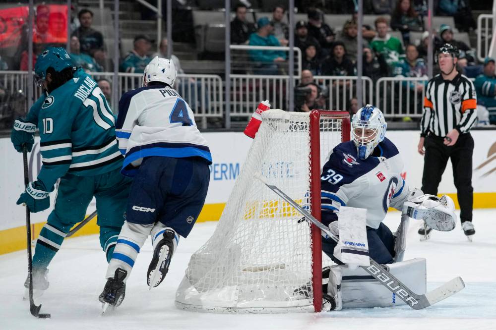Godofredo A. Vásquez / The Associated Press
San Jose Sharks left wing Anthony Duclair passes the puck behind his back while defended by Winnipeg Jets’ Neal Pionk during the third period.