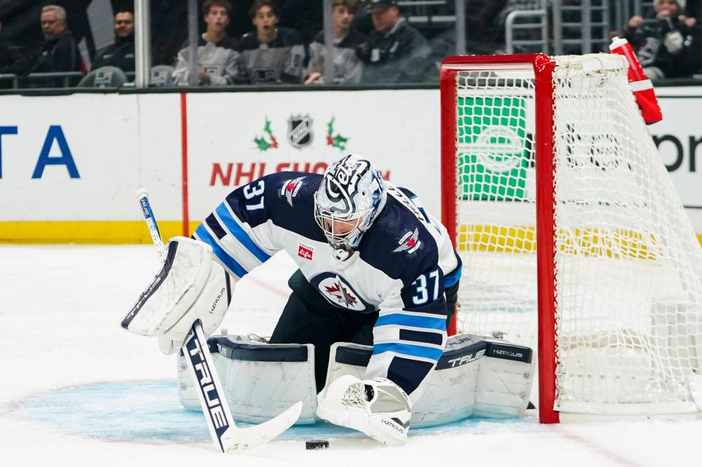 Ryan Sun / The Associated Press
Winnipeg Jets goaltender Connor Hellebuyck freezes the puck during the second period.