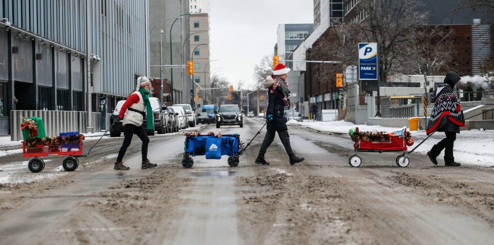 Urban Wagons volunteers trek along Graham Avenue with their wagons full of Christmas goodies. (John Woods / Winnipeg Free Press)